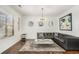 Stylish living room with black leather sofa, hardwood floors, a modern chandelier and wall decor at 2625 Lake Erma Dr, Hampton, GA 30228