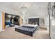 A main bedroom with a large bed, chandelier, and sitting area in neutral tones with carpet at 2625 Lake Erma Dr, Hampton, GA 30228