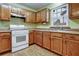 Bright kitchen with wood cabinets, tile floors and white appliances at 3815 Landgraf Cv, Decatur, GA 30034