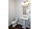 Charming bathroom featuring a pedestal sink, dark wood flooring, and white toilet at 5015 Montes Ln, Cumming, GA 30040