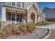 Charming front porch featuring stone accents, outdoor seating, and manicured landscaping at 5015 Montes Ln, Cumming, GA 30040