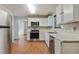 Kitchen with white cabinets, stainless steel appliances, and hardwood floors at 6738 Merrywood Dr, Fairburn, GA 30213