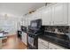 Modern kitchen with white cabinets, black countertops, and stainless steel appliances at 1809 Francon Sw Ct, Conyers, GA 30094