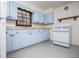 Bright kitchen with light blue cabinets, white appliances, and an exposed brick wall at 2283 Country Club Sw Ln, Atlanta, GA 30311