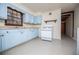 Bright kitchen with light blue cabinets, white appliances, and an exposed brick wall at 2283 Country Club Sw Ln, Atlanta, GA 30311