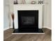 Close up view of a fireplace with black interior and white mantle surrounded by light hardwood floors at 28 Samuel Nw Way, Cartersville, GA 30121