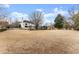 Large, flat backyard showing the rear of the house with mature trees and a white picket fence at 6310 Fox Creek Dr, Cumming, GA 30040