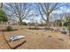 Expansive backyard featuring a pea gravel area with seating, cornhole boards, and mature trees at 6310 Fox Creek Dr, Cumming, GA 30040