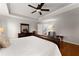 Main bedroom with hardwood floors, tray ceiling, a ceiling fan, and neutral tones at 6310 Fox Creek Dr, Cumming, GA 30040