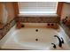 Oval bathtub with tile surround and window with blinds at 115 The Falls Blvd, Covington, GA 30016