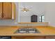 Kitchen with wood cabinets, double sink, and view into living room at 1440 Teaberry Cir, Lawrenceville, GA 30044