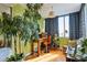 Bright home office features a large window, hardwood floors, and ample plant life at 215 Piedmont Ne Ave # 1707, Atlanta, GA 30308