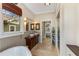 Bright bathroom featuring double sinks, a standalone tub, a walk-in shower, and access to the main bedroom at 1316 North Ne Ave, Atlanta, GA 30307