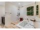 Bright bathroom with white tile shower, jacuzzi tub with jets, and attractive plant wall at 1316 North Ne Ave, Atlanta, GA 30307