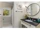 Elegant bathroom with dark countertop, round mirror, and hexagonal tile floor at 1316 North Ne Ave, Atlanta, GA 30307