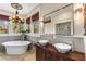 Bright bathroom featuring double sinks, a standalone tub, a walk-in shower, and picture windows at 1316 North Ne Ave, Atlanta, GA 30307