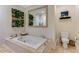 Bright bathroom with white jacuzzi tub, a tile surround, with adjacent toilet, and a lush plant wall at 1316 North Ne Ave, Atlanta, GA 30307