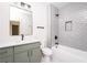 Contemporary bathroom with green vanity, grey tile, and black accents at 17 Rockyford Ne Rd, Atlanta, GA 30317