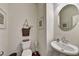 Small bathroom with pedestal sink and round mirror at 1934 Asher Ln # 060, Conyers, GA 30013