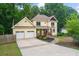 Two-story house with a long driveway, two-car garage, and landscaped yard at 2010 Sturbridge Ln, Buford, GA 30519