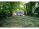 Scenic view of a backyard with lush greenery, mature trees, and a charming one-story home at 2064 Chicago Nw Ave, Atlanta, GA 30314