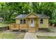 Charming exterior view of a small, yellow, one-story home with a new deck and well-maintained landscaping at 2064 Chicago Nw Ave, Atlanta, GA 30314