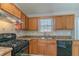 Kitchen corner with wood cabinets, black appliances, and tile backsplash at 2675 Park Ave, Austell, GA 30106