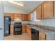 Galley kitchen with wood cabinets, black appliances, and tile flooring at 2675 Park Ave, Austell, GA 30106