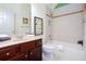 Well-lit bathroom featuring a tub with tile surround, wood vanity, and artistic accents for a refreshing experience at 101 Chestnut Dr, Canton, GA 30114