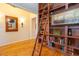 Hallway view of the built-in bookshelf with ladder, mirror, and hardwood floors at 101 Chestnut Dr, Canton, GA 30114