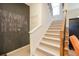 Carpeted stairs with wooden railing next to a chalkboard wall with white trim at 101 Chestnut Dr, Canton, GA 30114