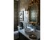 Stylish bathroom featuring a round sink, luxurious gray wallpaper, and an ornate gold-framed mirror at 210 Marjean Way, Alpharetta, GA 30009