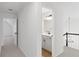 Upstairs hallway leading to a bathroom with a gray vanity and a staircase at 160 Lofty Eagle Ln, Fayetteville, GA 30214