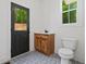 Small bathroom with wood vanity, patterned floor tile, and white toilet at 115 Palisade Dr, Rydal, GA 30171