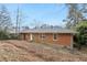 View of a brick home exterior with a spacious backyard and mature trees at 1820 Arkose Dr, Atlanta, GA 30316