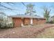 Backyard view of single-story brick home with fenced yard and mature trees at 1820 Arkose Dr, Atlanta, GA 30316