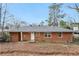 Exterior view of a single story home with a brick exterior and spacious backyard at 1820 Arkose Dr, Atlanta, GA 30316