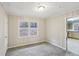 Neutral bedroom featuring new gray carpet and paneling on the walls, with a door leading to the kitchen at 1820 Arkose Dr, Atlanta, GA 30316