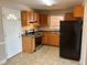 Bright kitchen includes wood cabinets, stainless steel appliances, black fridge and linoleum flooring at 1820 Arkose Dr, Atlanta, GA 30316