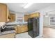 Kitchen with wood cabinets, black appliances, and view to living area at 1820 Arkose Dr, Atlanta, GA 30316