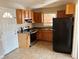 Traditional kitchen featuring wood cabinets, black appliances, a double-basin sink, and a door to the left at 1820 Arkose Dr, Atlanta, GA 30316