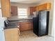 Functional kitchen features wood cabinets, a double sink beneath a window, and a black refrigerator at 1820 Arkose Dr, Atlanta, GA 30316