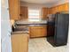 Functional kitchen features wood cabinets, a double sink beneath a window, and a black refrigerator at 1820 Arkose Dr, Atlanta, GA 30316