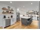 Modern kitchen with white cabinets, a large island and floating shelves at 1300 Bridgewater Walk, Snellville, GA 30078