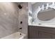 Updated bathroom with gray marble tile and a white bathtub at 970 Sidney Marcus Ne Blvd # 2113, Atlanta, GA 30324