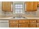 Kitchen with wood cabinets, neutral countertops, and a window at 396 Southern Trace Dr, Rockmart, GA 30153