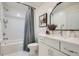 Well-lit bathroom featuring a shower over tub, decorative mirror, and stylish vanity at 400 Pratt Se Dr # 1403, Atlanta, GA 30315
