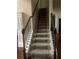 Carpeted staircase featuring dark wood railings and decorative iron spindles at 4300 Henry Rd, Snellville, GA 30039