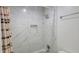 Modern bathroom features marble-style tiling, shower head, built-in shelf and curtain at 507 Augusta Se Dr, Marietta, GA 30067