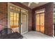 A cozy balcony showcases brick walls, outdoor seating, and access to bright interiors with french doors at 273 12Th Ne St # 210, Atlanta, GA 30309